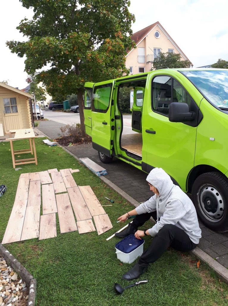 Birgit's mission: Move the flooring from the green grass to the green camper.