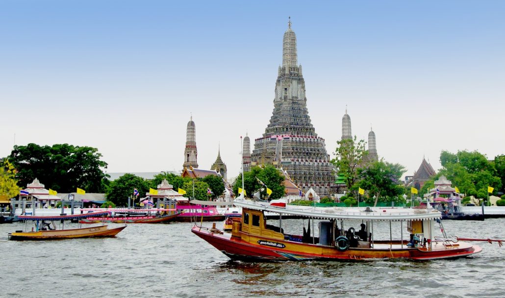 Taking a boat tour on the Chao Phraya River with Wat Arun in the background